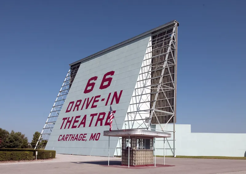 Big white screen of the 66 Drive-In Theatre under blue sky in Carthage, Missouri
