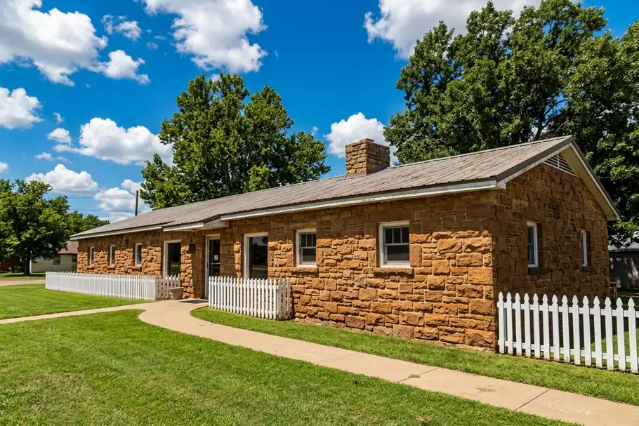 The sandstone Rock Cafe with a white picket fence on a summer day in Stroud, Oklahoma