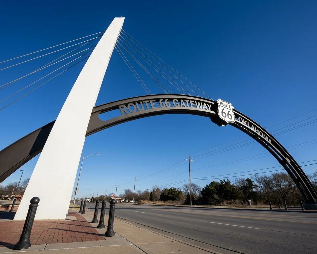 Leaning white pylon and steel arch of the Route 66 Gateway on Southwest Boulevard, Tulsa