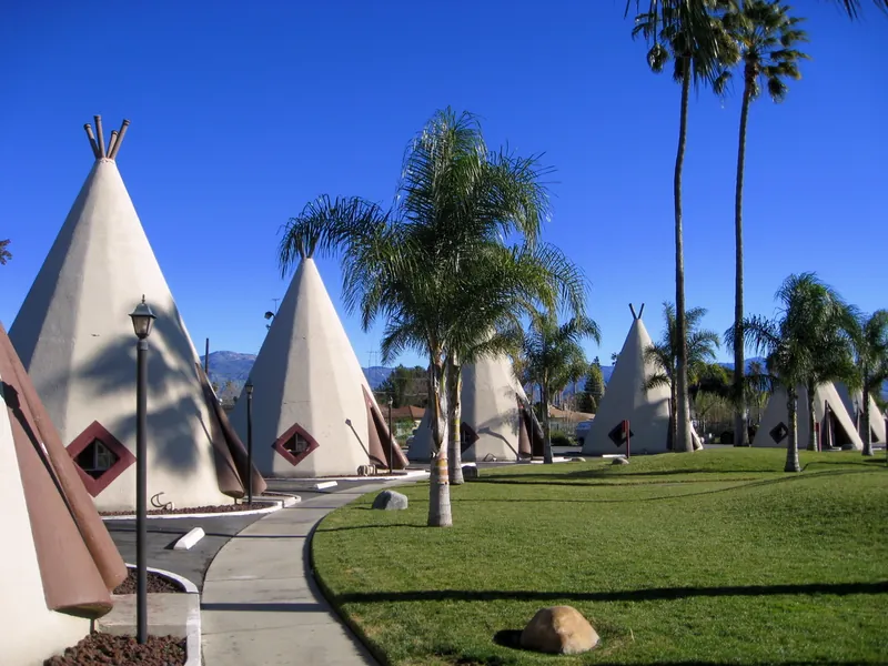 Concrete tepee rooms and palm trees at the Wigwam Motel near San Bernardino, California